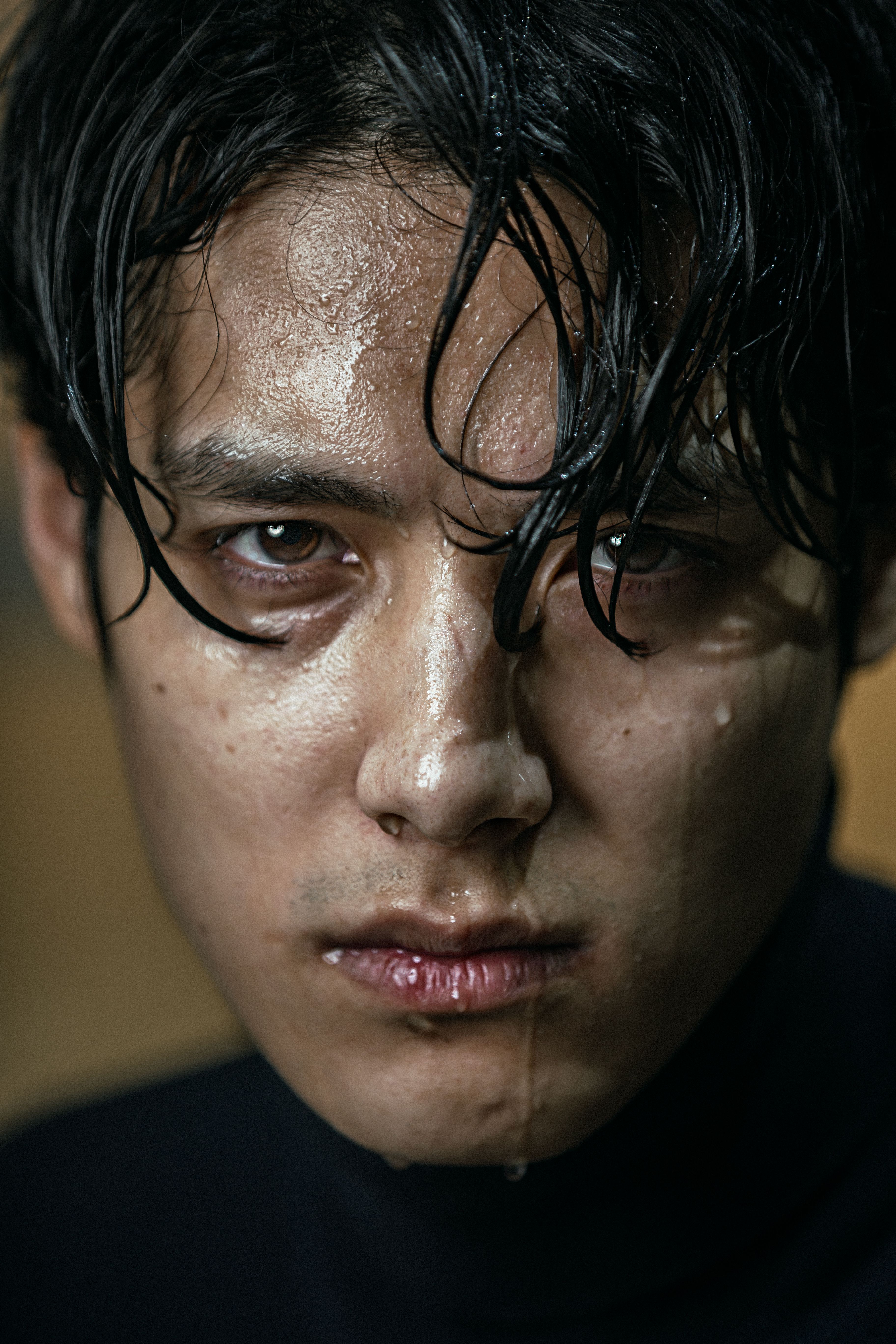 Close-up portrait of a wet man with intense expression.
