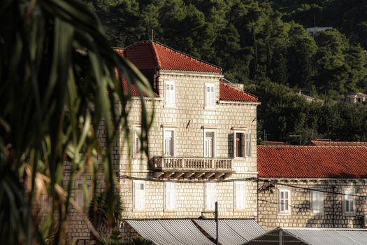 A picturesque stone building with red rooftops in Lopud island, Croatia.