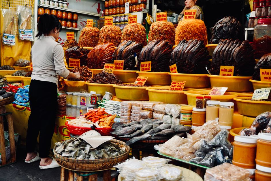 Vietnamese fried squid cake and packaged seafood gifts in a Mong Cai specialty shop, clean display shelves, gift-ready arrangement, highly detailed