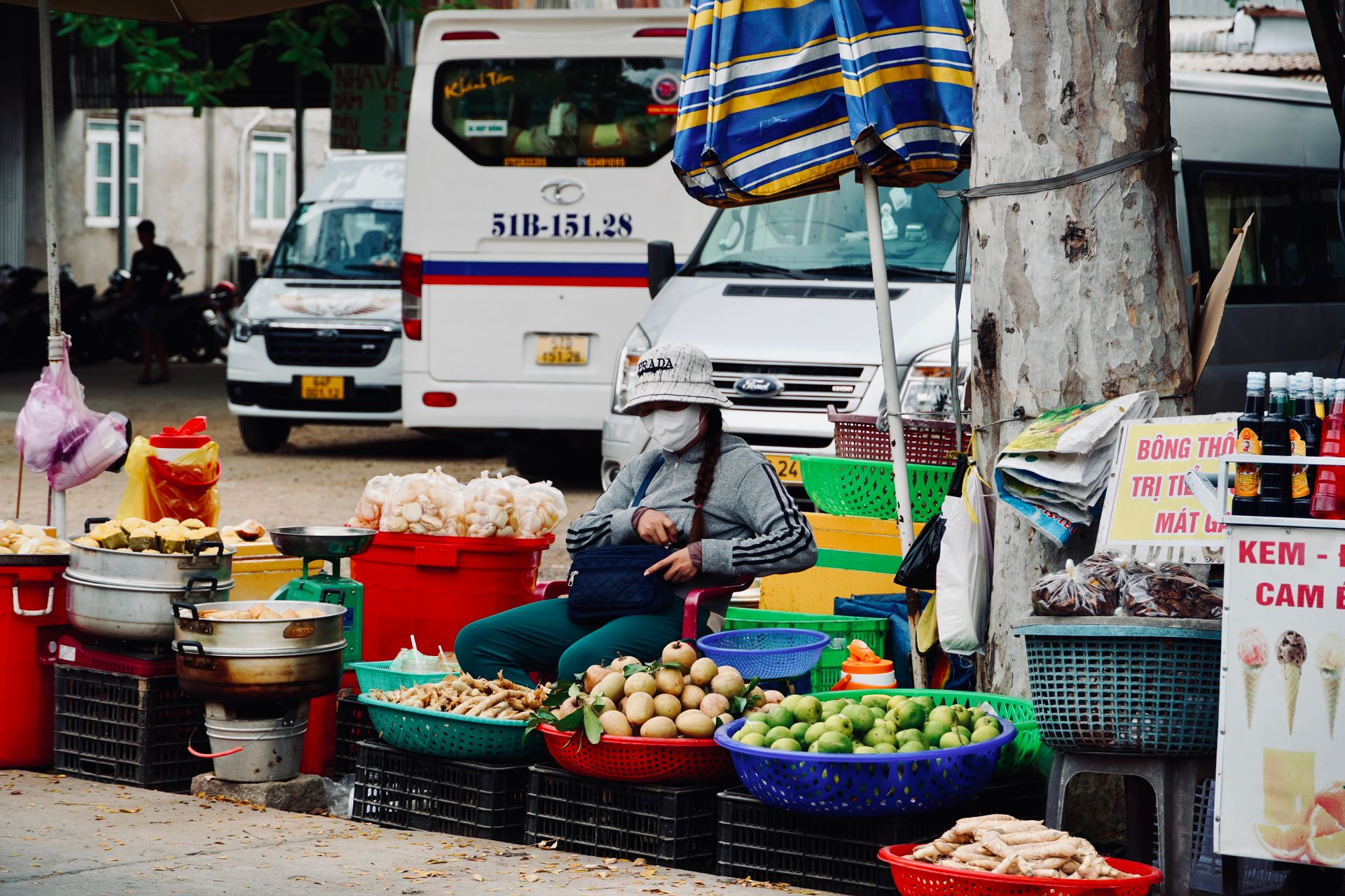A vibrant street market scene featuring a fruit vendor in an urban setting in Vietnam.