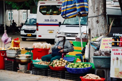 Free A vibrant street market scene featuring a fruit vendor in an urban setting in Vietnam. Stock Photo