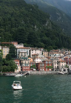 Charming colorful houses along Lake Como, Italy's lush green hills.