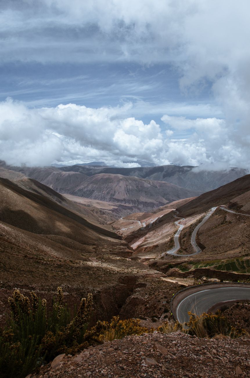 Curvy mountain road under a dramatic sky. Ideal for travel and adventure themes.