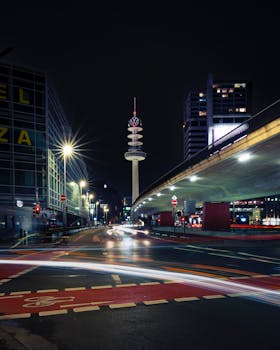 Dramatic night scene in Hannover showcasing Niederpost's Telekom Tower and vibrant city lights.