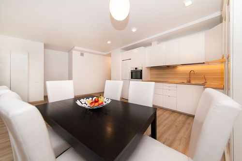 Free A sleek, modern kitchen with a minimalist design and dining set with fruit bowl. Stock Photo