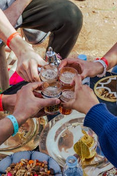 Five people toasting with Moroccan tea at an outdoor setting in Marrakesh.