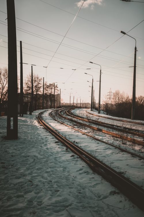 Free Winter scene of railway tracks curving through snow-covered landscape under a clear sky. Stock Photo