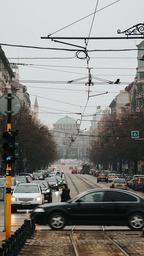 Free Dynamic view of a bustling street in Sofia with traffic and landmark in the distance. Stock Photo