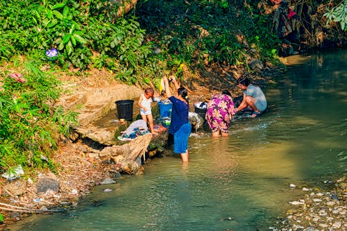 Wanita Mencuci Pakaian Di Tepi Sungai