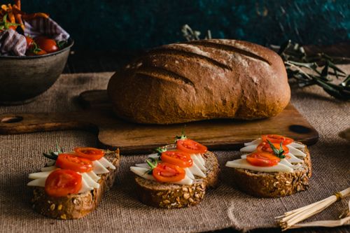 Free Rustic multi-grain bread with fresh cheese and tomato slices, perfect for a healthy snack. Stock Photo