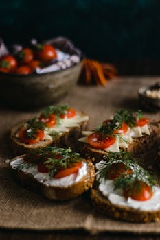 Artistic display of multi-grain bread topped with cherry tomatoes and herbs, perfect for food lovers.