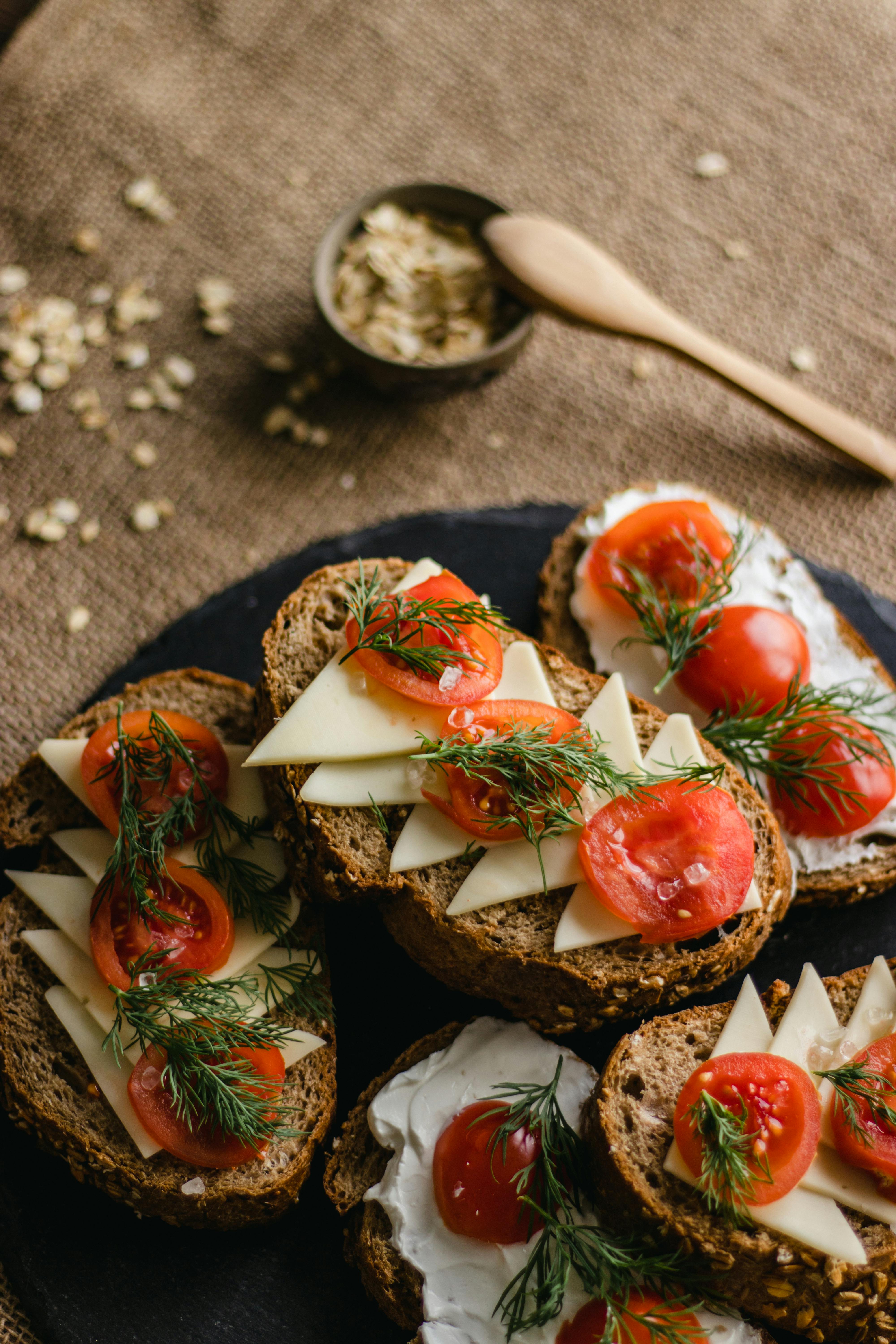Sliced multi-grain bread topped with cheese, tomatoes, and herbs. Perfect for breakfast or snack.