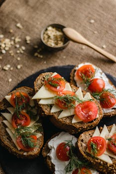 Sliced multi-grain bread topped with cheese, tomatoes, and herbs. Perfect for breakfast or snack.