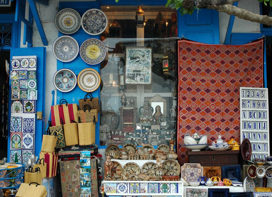 Vibrant display of traditional Moroccan crafts, ceramics, and textiles in a local artisan shop.