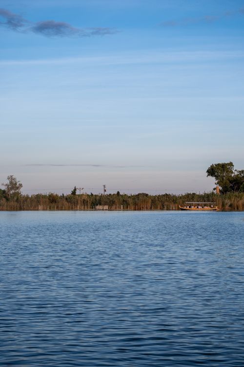 Free Tranquil lake reflecting the serene sky at sunset, perfect for relaxation and nature lovers. Stock Photo