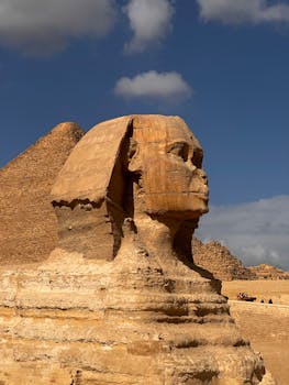 Iconic Great Sphinx of Giza with pyramid in background, showcasing ancient Egyptian architecture.