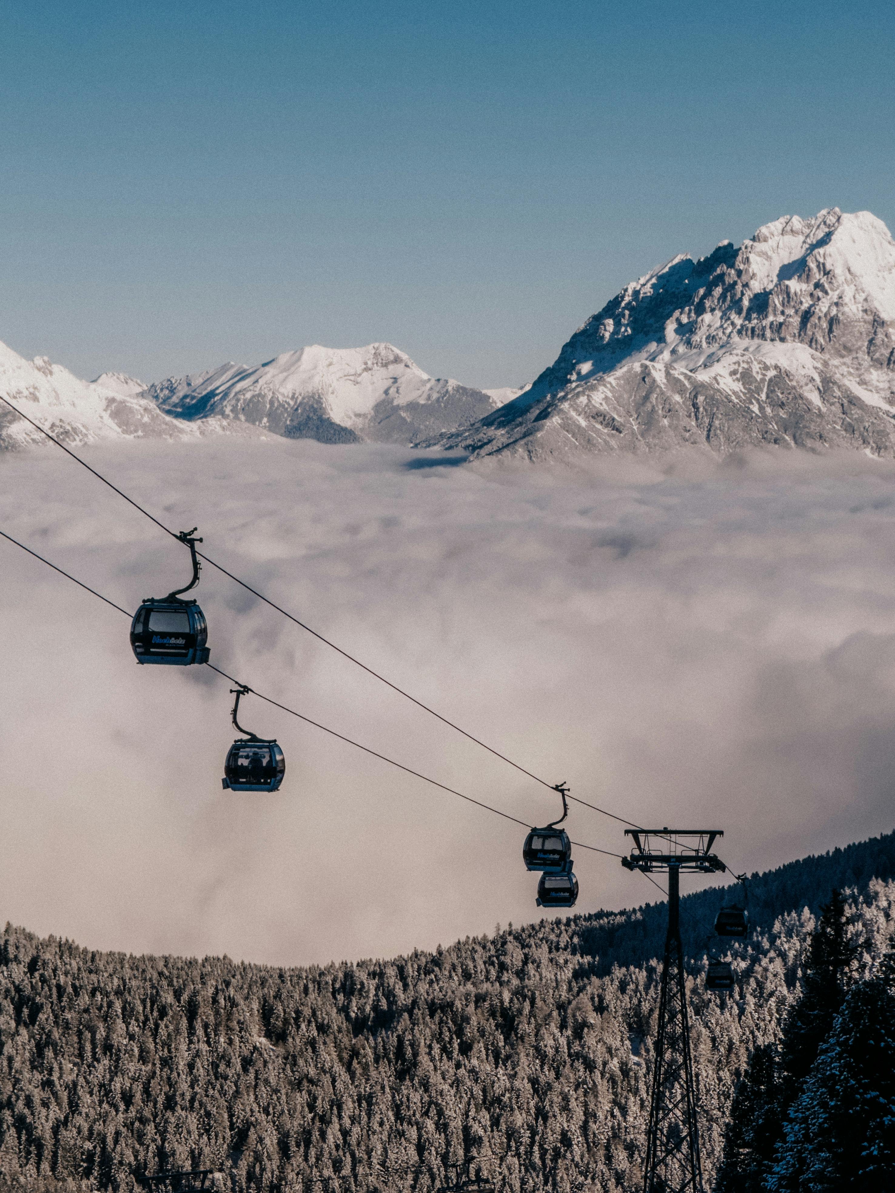 Breathtaking view of cable cars over the snow-laden Alps in Tirol, Austria's winter wonderland.