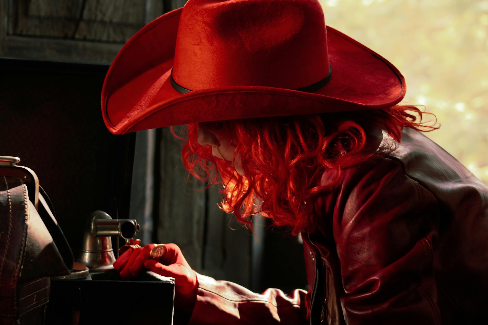 Portrait of a person in red hat and leather jacket, exuding a vintage vibe in warm lighting.