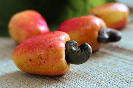 Close-up of ripe cashew fruits with nuts on a woven mat, highlighting their vibrant colors.