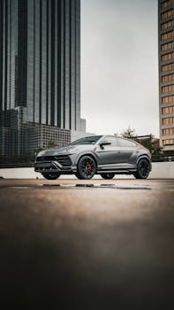 Modern luxury SUV parked in an urban cityscape with skyscrapers in the background.