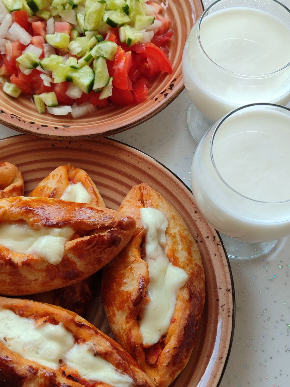 Golden-brown Turkish köfte burger nestled in warm pide bread, generously topped with creamy yogurt-herb sauce, fresh tomatoes, red onion, and crisp lettuce