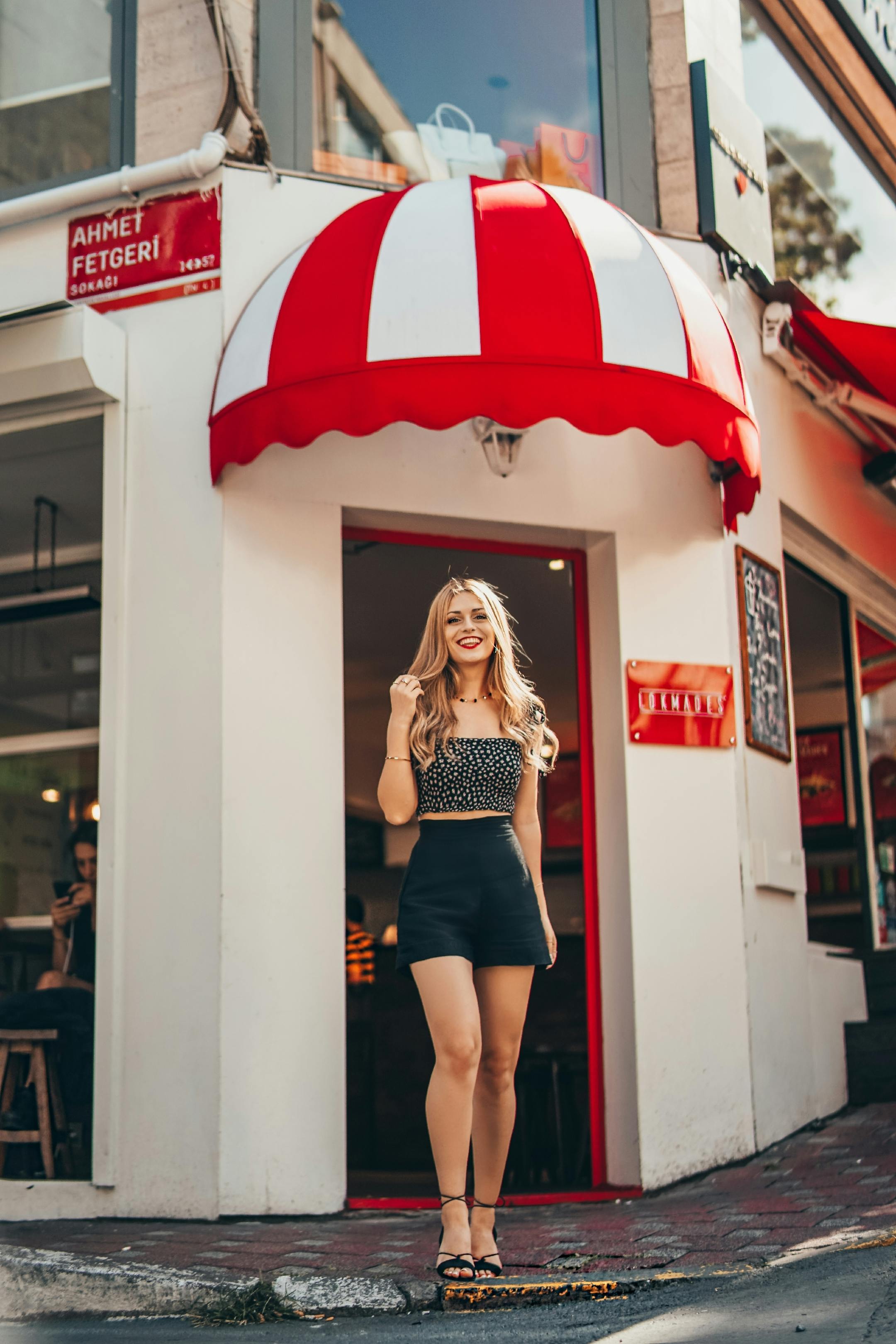 Free Stylish woman posing confidently outside a colorful cafe in Istanbul, Turkey. Stock Photo