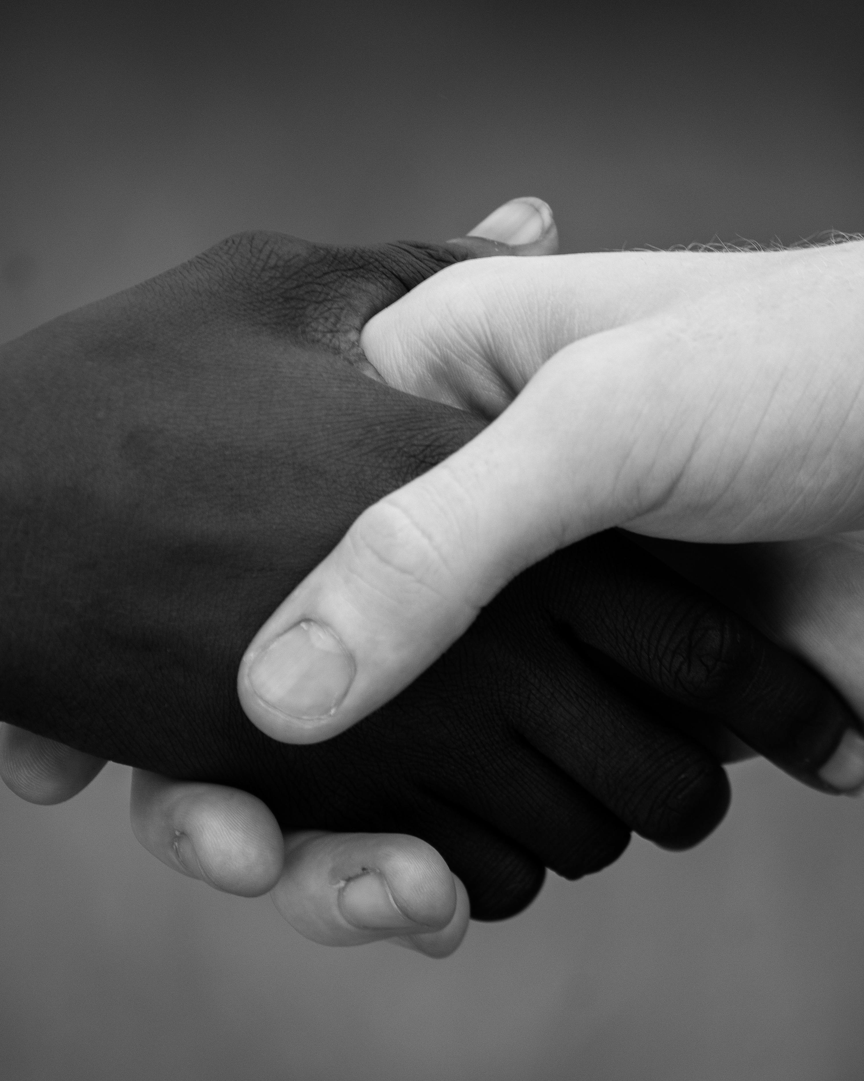 Gratis Primo piano di una foto in bianco e nero di diverse mani giunte, a simboleggiare l'unità. Foto a disposizione