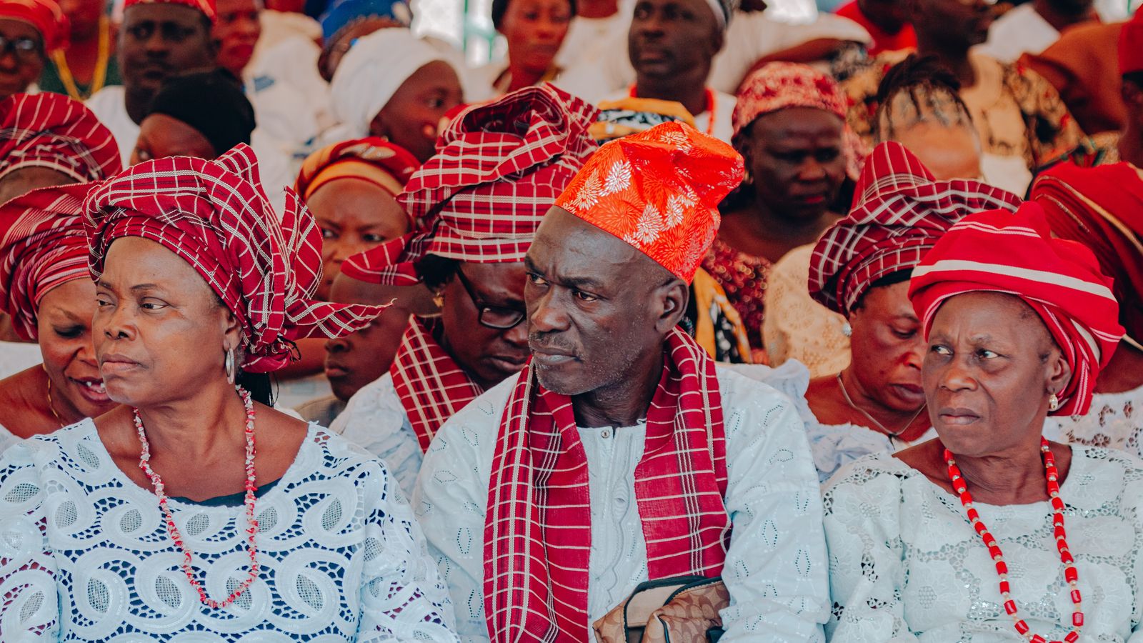 A vibrant display of cultural attire at a Nigerian gathering showcasing traditional clothing and headwear.