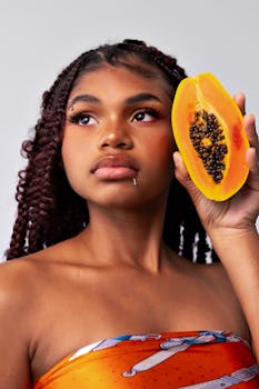 Portrait of an African woman with a papaya slice, showcasing natural beauty and tropical vibes.