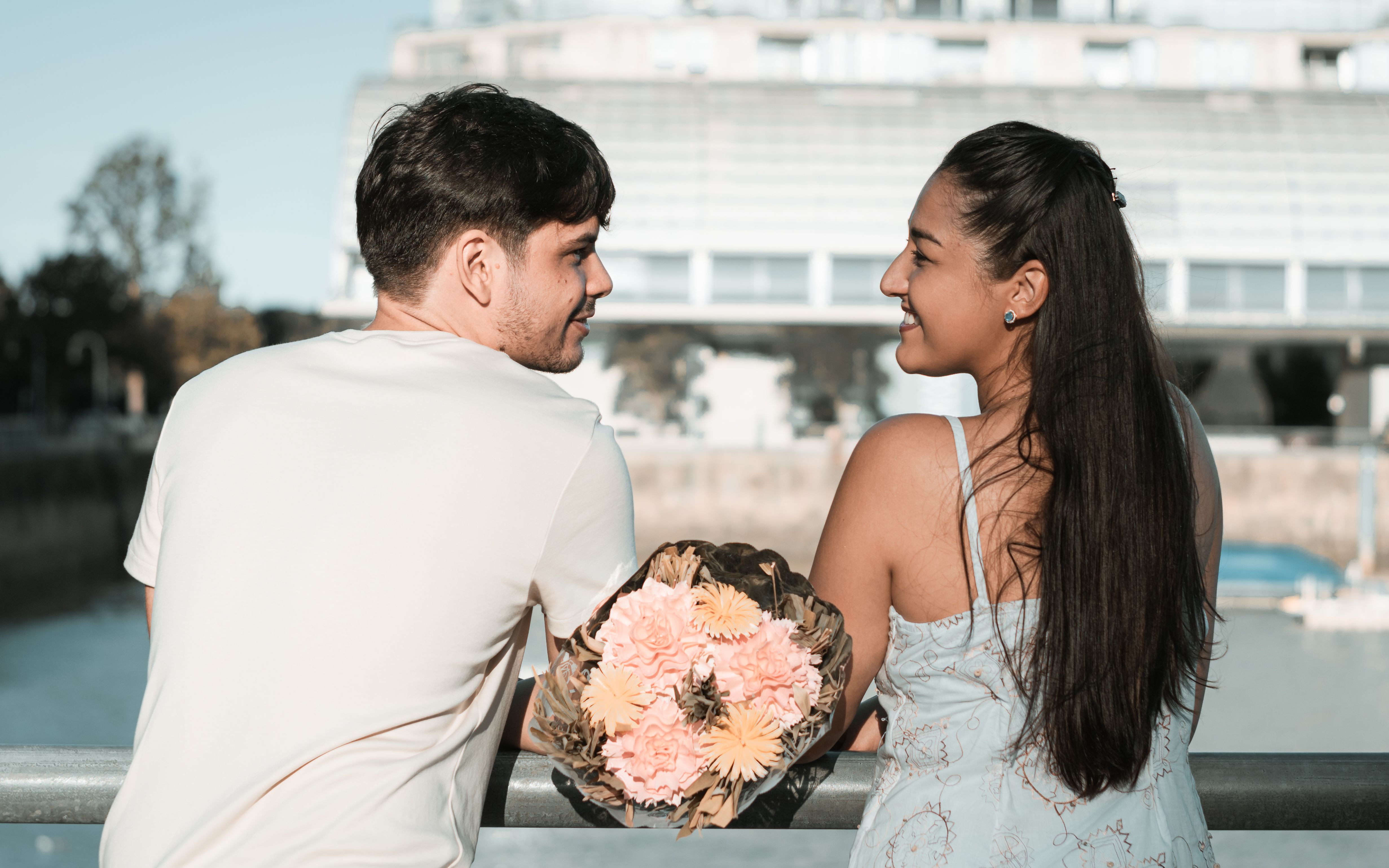 A couple enjoying a romantic moment with flowers on a bridge in Buenos Aires.