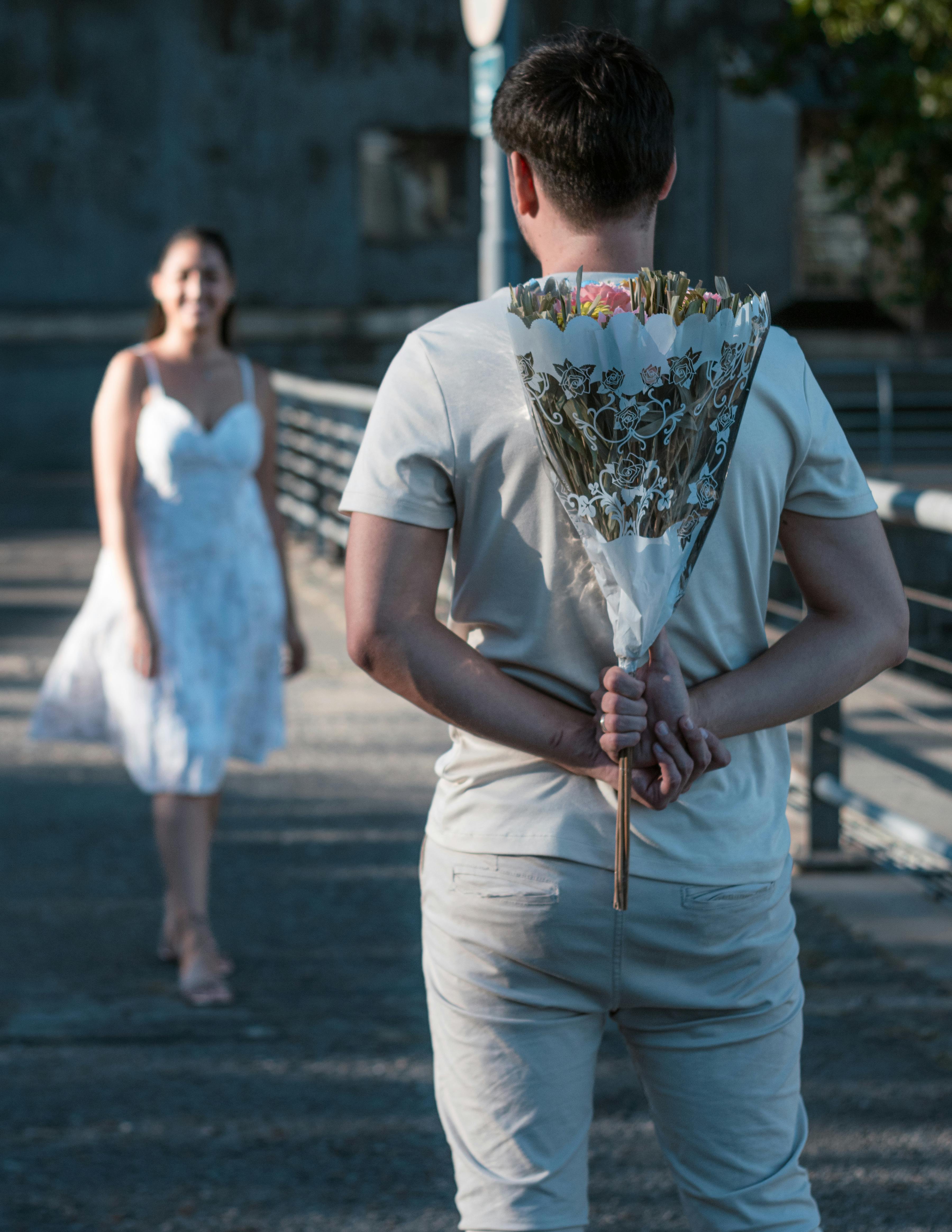 Man surprises woman with flowers on a street in Buenos Aires, embodying love and romance.