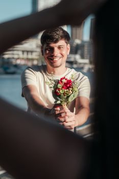 Young man offering flowers in a romantic outdoor setting in Buenos Aires.