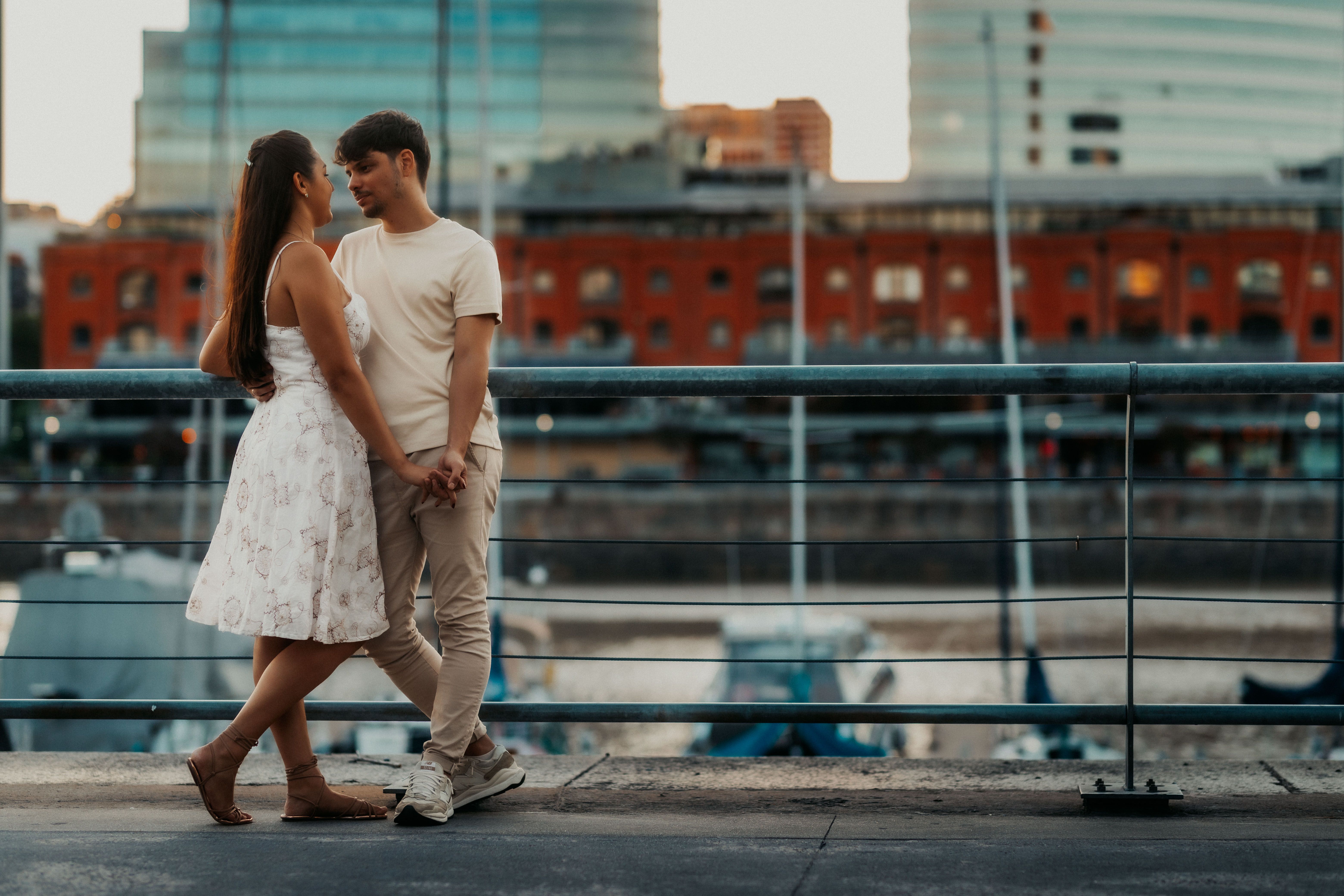 A romantic couple enjoying a moment together at Puerto Madero, Buenos Aires during sunset.