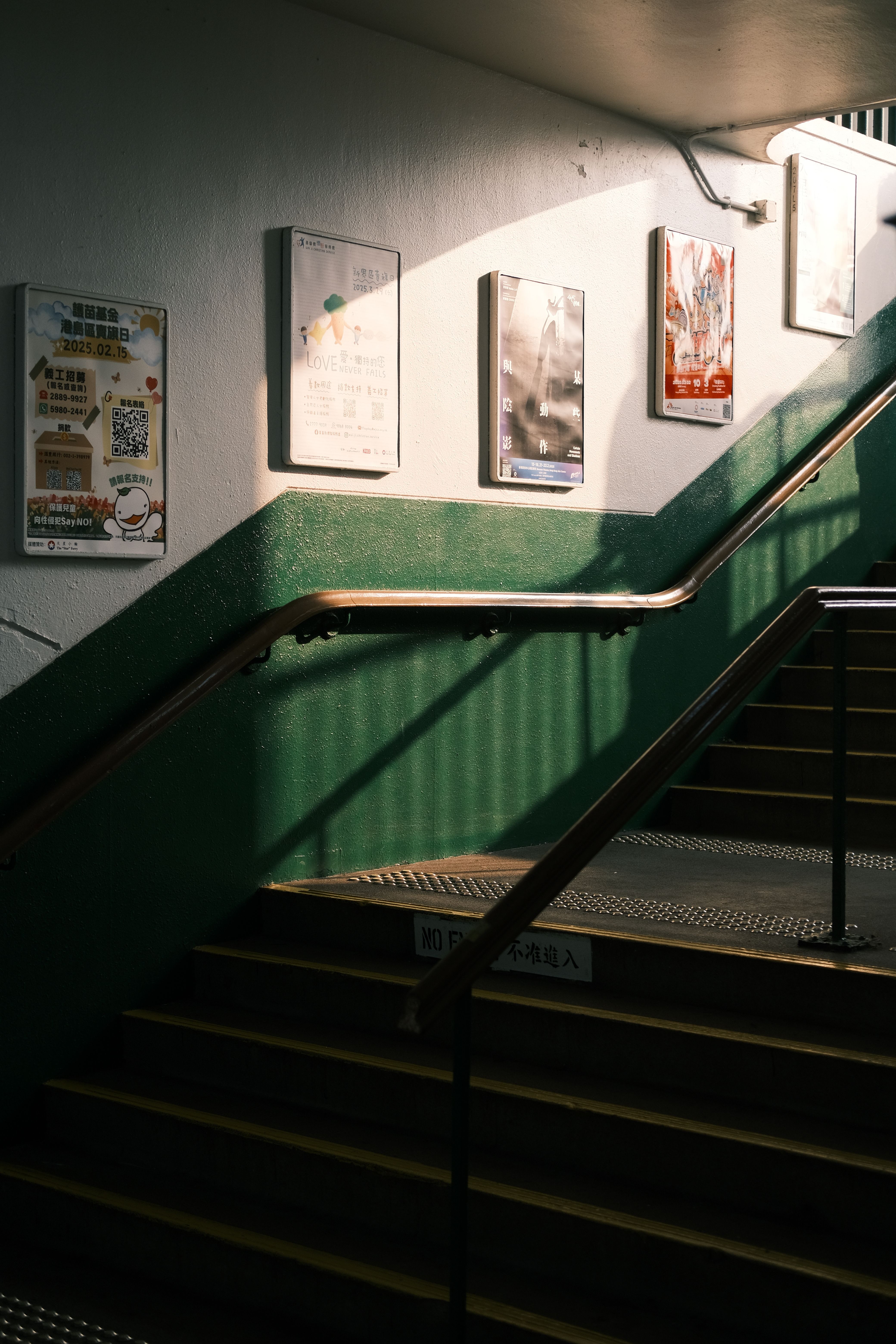 A well-lit subway staircase featuring colorful posters, representing urban commuting.