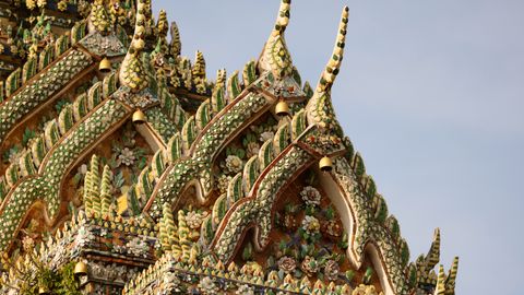 Close-up of ornate roof architecture at Wat Pho, showcasing traditional Thai design and craftsmanship.