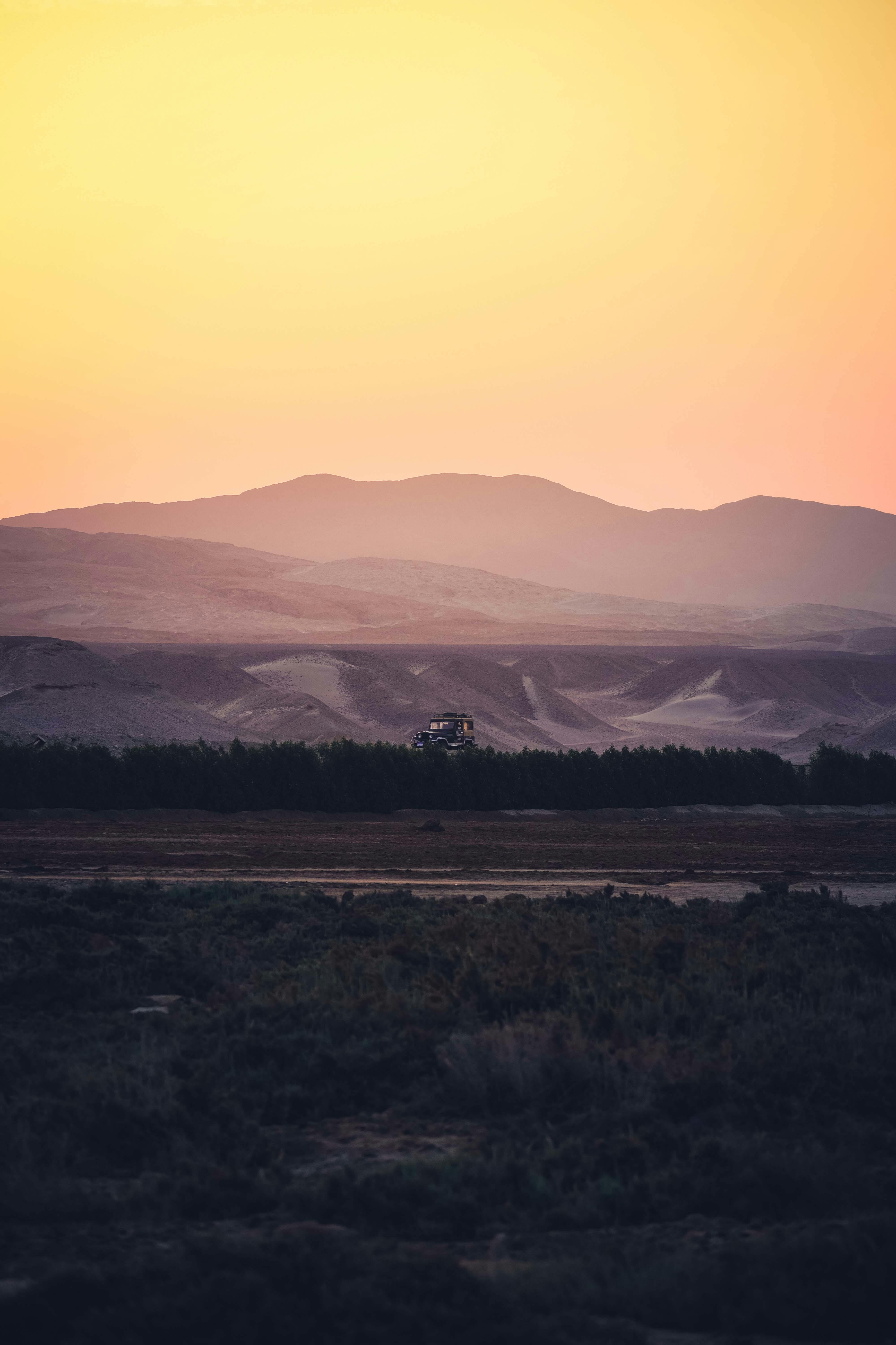 日落时分，山景壮丽，天空柔和，丘陵起伏