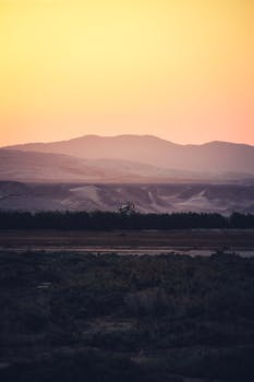 日落时分，山景壮丽，天空柔和，丘陵起伏