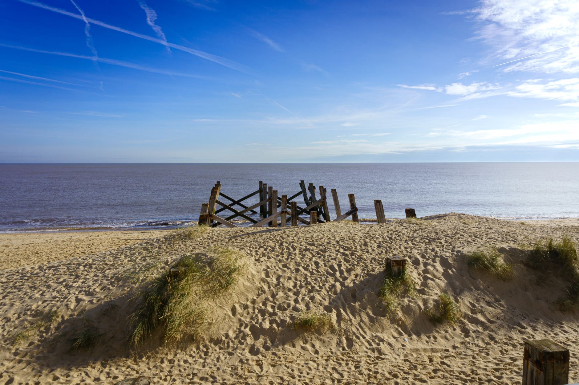 Beautiful beach landscape in Great Yarmouth with old wooden structure and clear skies.
