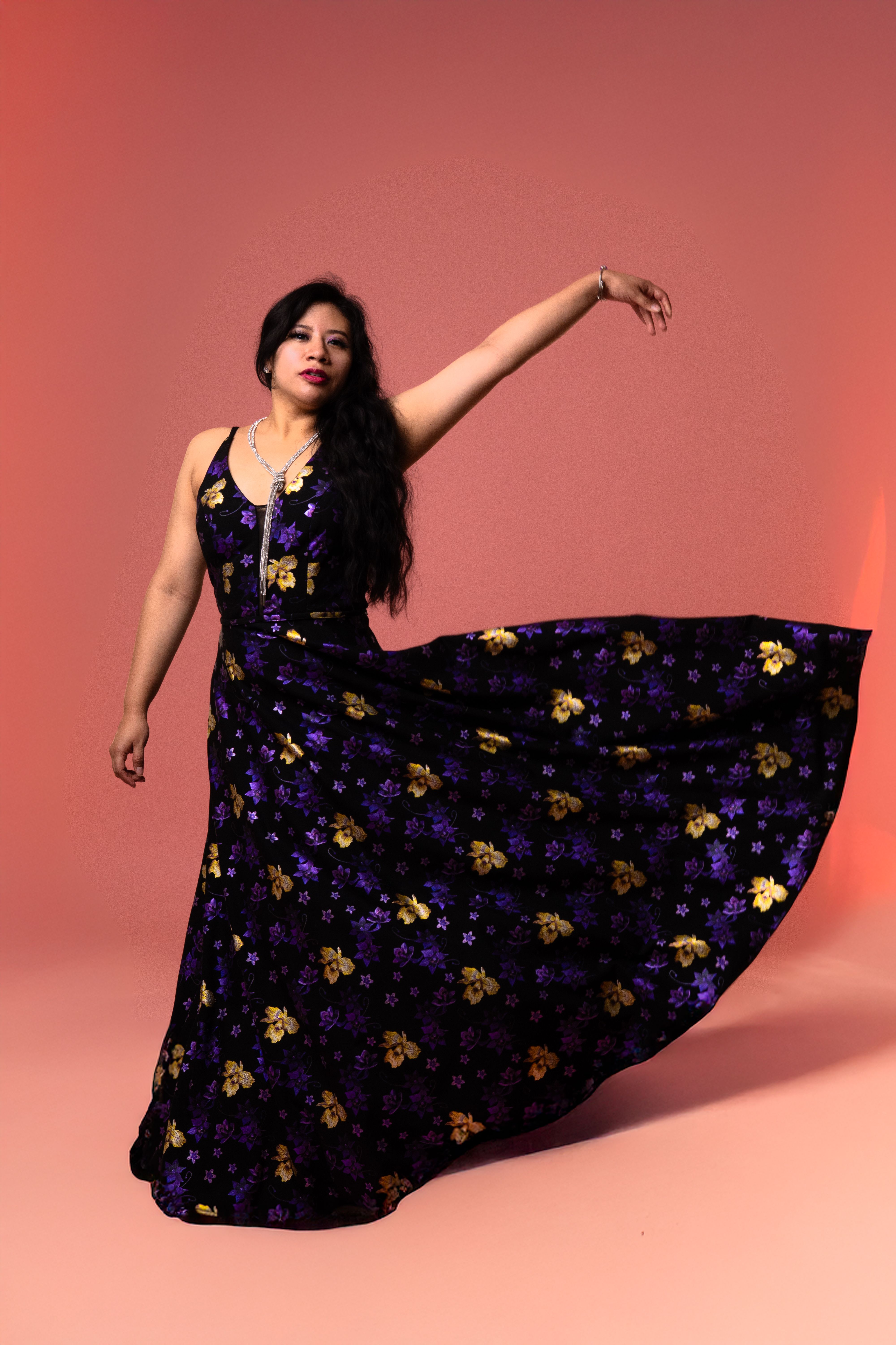 Elegant Woman Posing in a Flowing Floral Dress · Free Stock Photo