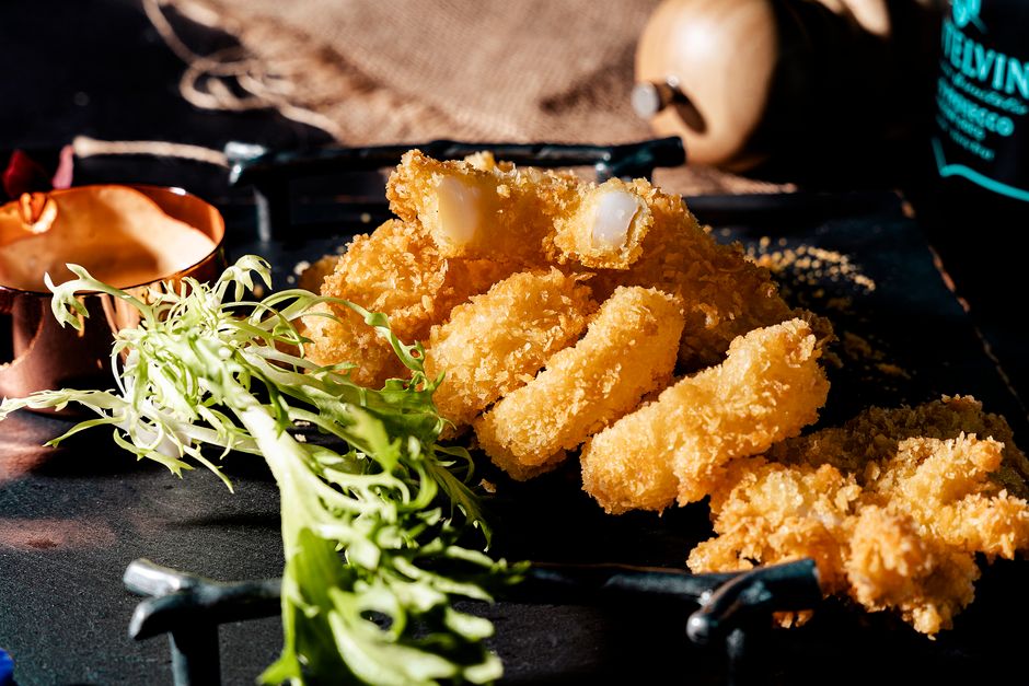 Golden crispy fish fingers served with fresh greens and dipping sauce.