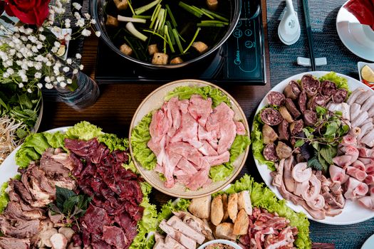 A variety of fresh meat and vegetables for making a traditional Asian hotpot meal.