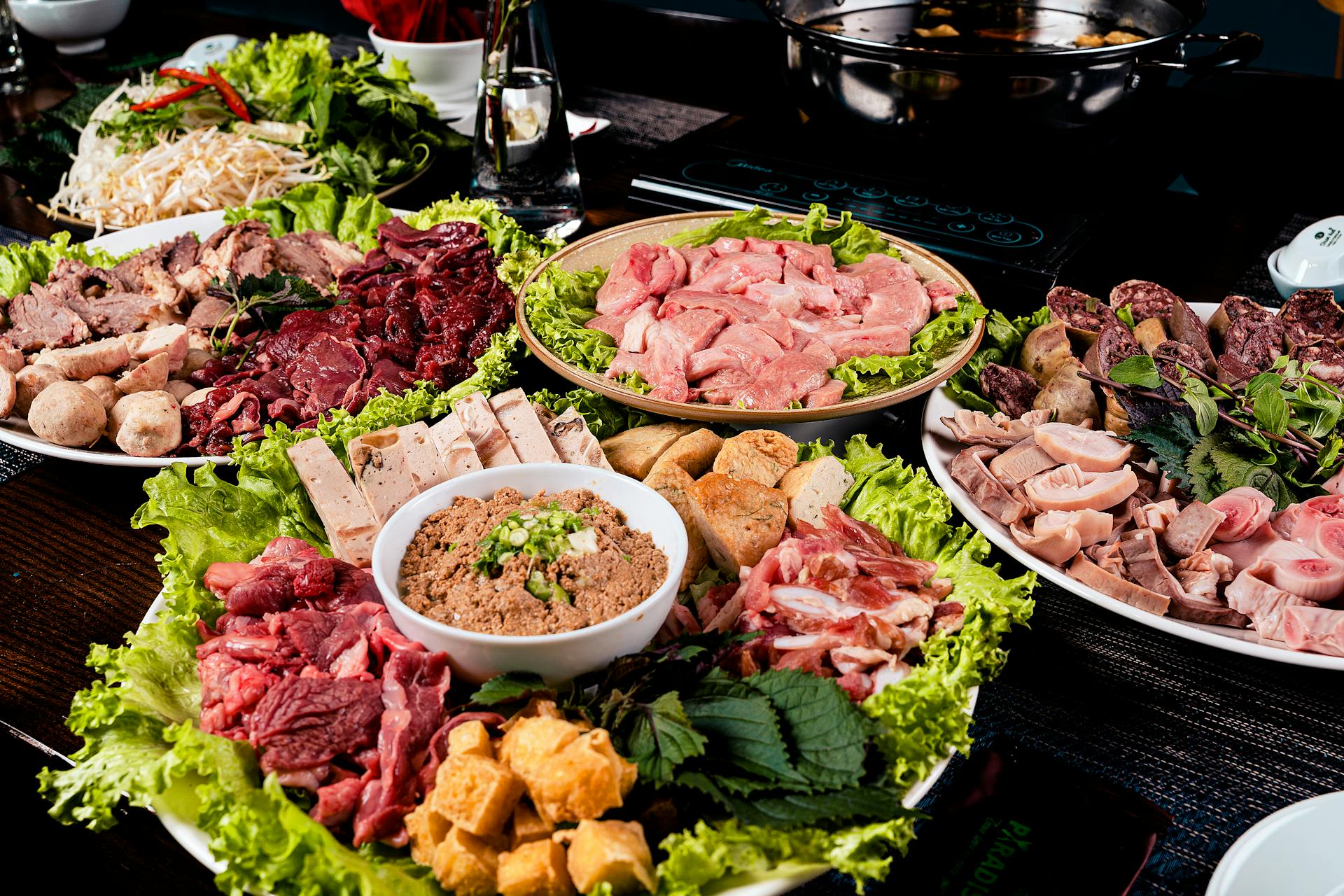 A vibrant assortment of meats and vegetables prepared for a traditional Asian hotpot meal.