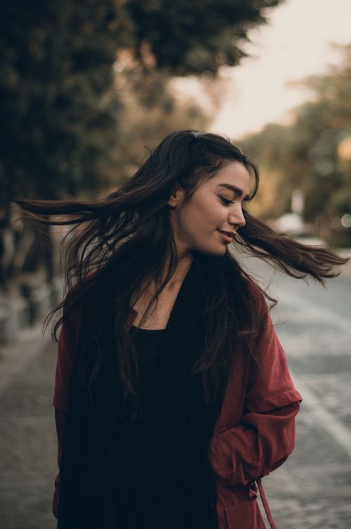 Free A woman with long hair flipping it outdoors, exuding confidence and joy. Stock Photo