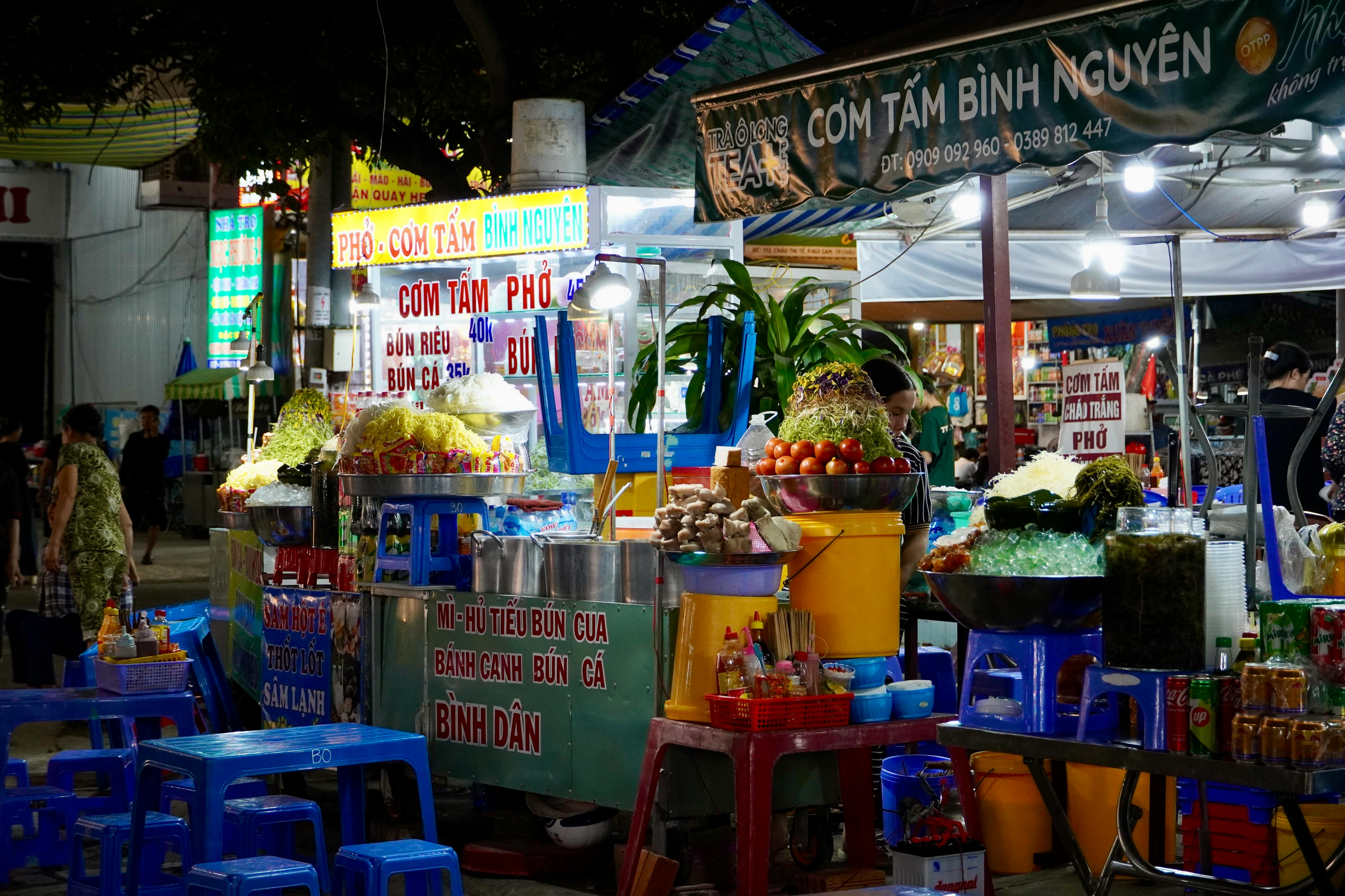 Colorful street food stalls at a bustling Vietnamese night market.