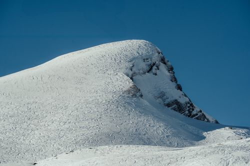 Free Serene snow-covered mountain peak contrasting with a clear blue sky, perfect for winter and nature themes. Stock Photo