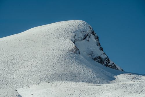 Free A stunning snow-covered mountain peak under a clear blue sky, ideal for nature and travel themes. Stock Photo