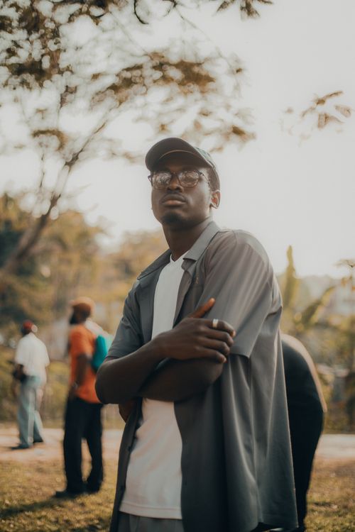Free A young man poses outdoors in a casual outfit, daytime setting. Stock Photo