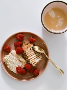 Tasty dessert with raspberries and coffee on white background. Perfect for food lovers.