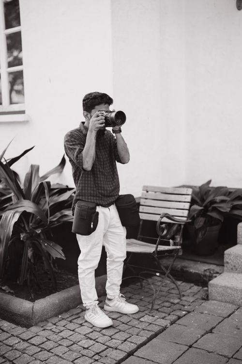 Free A young adult male photographer taking photos outdoors in Kochi, India. Stock Photo