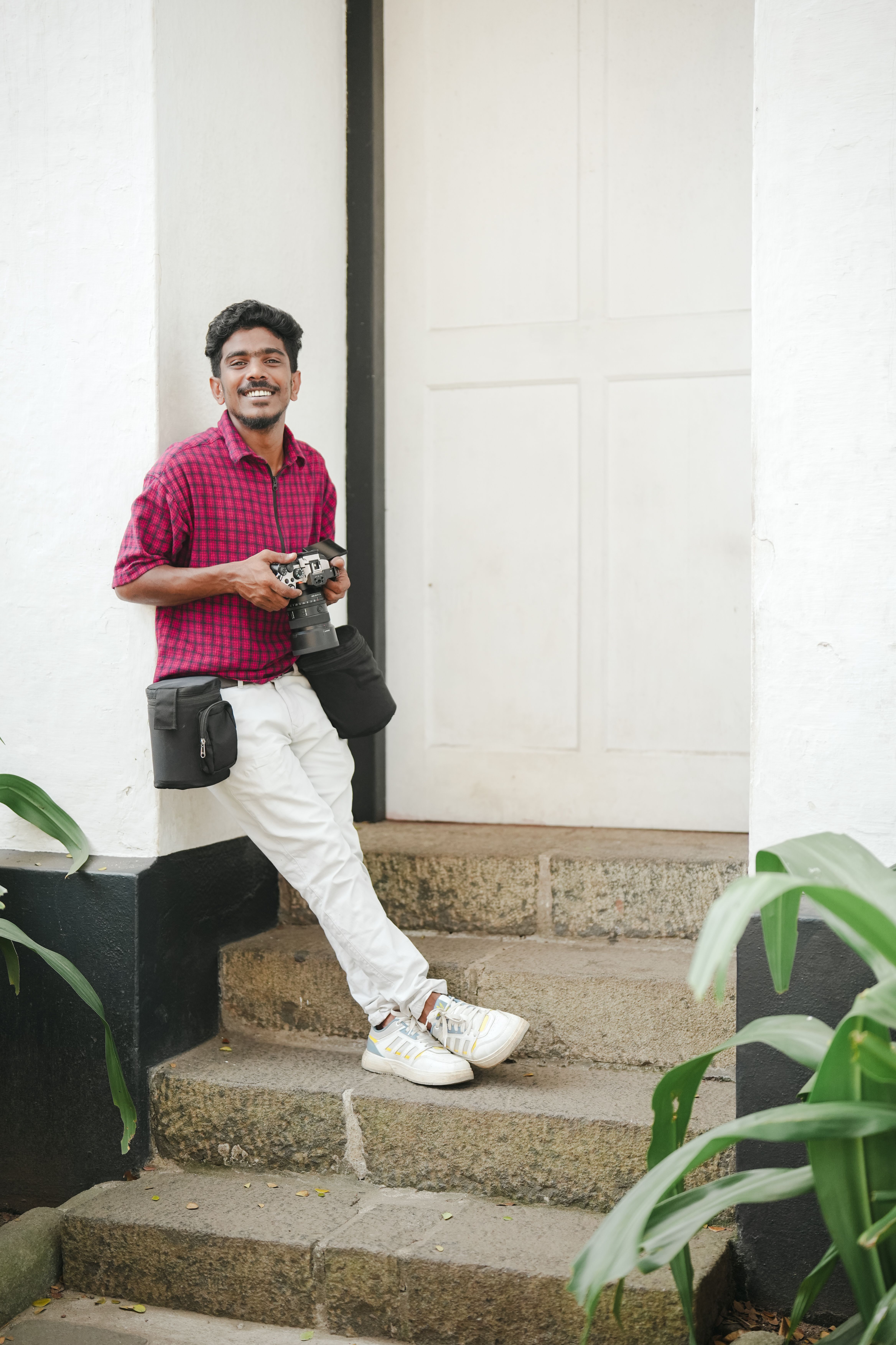 Cheerful photographer leaning on steps in Kochi, Kerala, India.